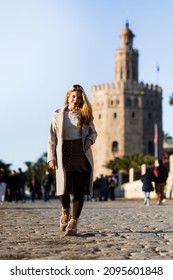 Young Teenage Girl Walking Down The Street In A Winter Coat In Seville, Spain.