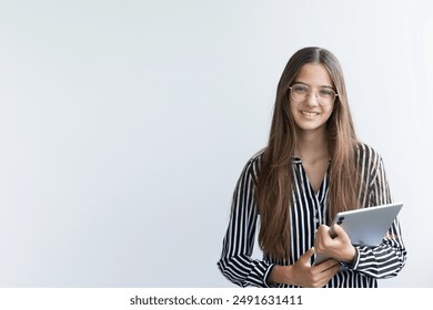 Young teenage girl wearing glasses smiling and holding digital tablet while standing over white background. Business concept with tablet. Place for text. - Powered by Shutterstock