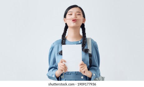 Young Teenage Student Freaking Out And Holding Her Pencil Between Nose And Lips As Moustache Looking Funny And Naughty