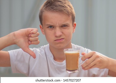 Young teenager boy hate coffee, drink it and wrinkle. Not tasty drink. Bad quality service in the cafe. Man do not like coffee and refuses to drink it.