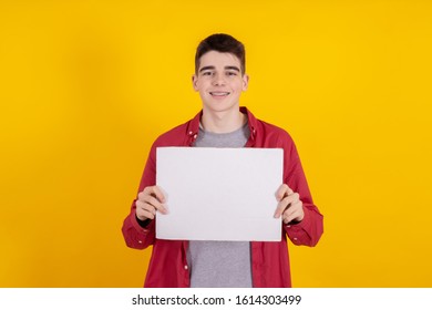 Young Teenager Boy Holding Sign Or Signboard Isolated On Color Background