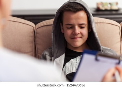 Young teenager boy sitting at counseling - in front of the therapy professional, close up