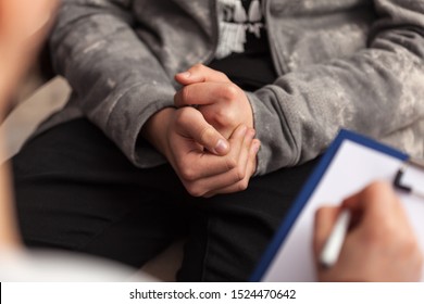 Young teenager boy uncomfortable at counseling - close up on clutching hands