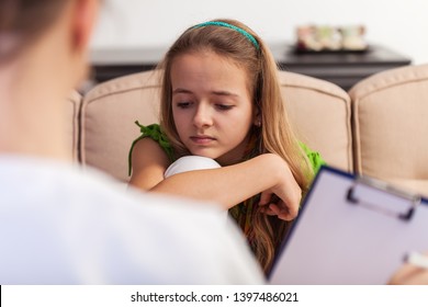 Young Teenager Girl Looking Bored And Sad, Sitting At Counseling In Front Of Professional Woman Assessing Her State - Close Up