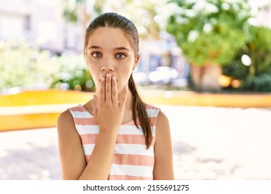 Young Teenager Girl Outdoors On A Sunny Day Covering Mouth With Hand, Shocked And Afraid For Mistake. Surprised Expression 