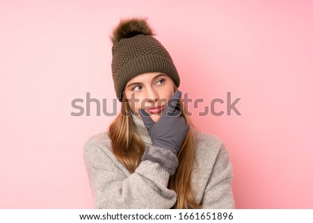 Young teenager girl with winter hat over isolated pink background thinking an idea