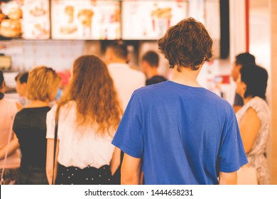 young teenager standing in a queue to receive the fastfood package - Powered by Shutterstock