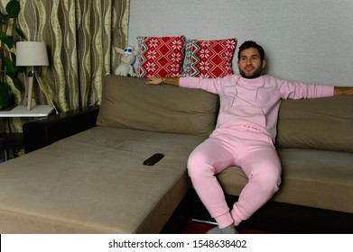 Young Television Addict Man Sitting On Sofa At Home And Watching TV Using Remote Control, Looking Excited, Pumping Out Someone Else's Comedy Comedy Movie Or Live Music At Night