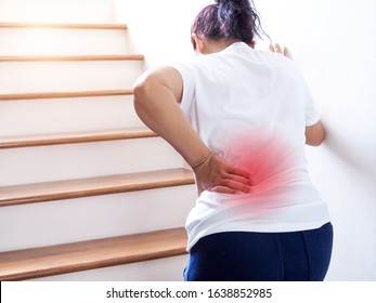 Young Thai Asian Woman Suffering Low Back Pain And Waist Lumbar Pain When Walking Up The Stairs.