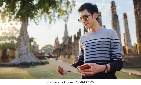 Young Thai Male Tourist With Map At Sukhothai Historial Park Thailand