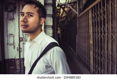 Young Thai Man Walking Out Of A Narrow Dark  Alley In Bangkok