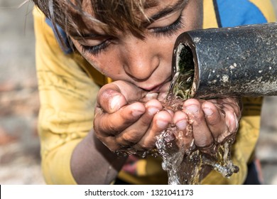 a young thirsty boy is drinking clean and sweet water  