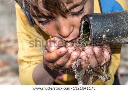 a young thirsty boy is drinking clean and sweet water  