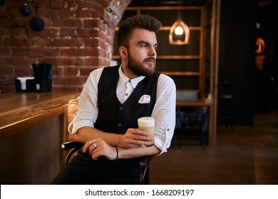 Young Thoughtful Casino Worker Having A Rest On The Chair, Close Up Side View Photo.