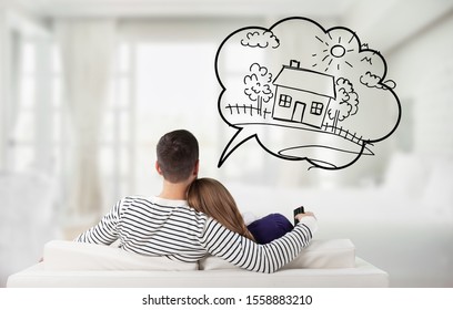 Junge, nachdenkliche Paare, die auf Sofa sitzen, denken daran, ihr eigenes Haus zu bekommen