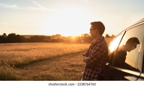 Young thoughtful handsome man looking out to the sunset from his car - Powered by Shutterstock