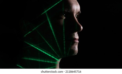 Un hombre joven y reflexivo de perfil, silueta sobre un fondo negro, proyecciones de patrones de colores en su cara, hombre y tecnología, concepto