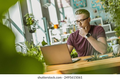 Young thoughtful manager freelancer student business man sit works remote studding at office home desk looks at laptop screen thinks over problem, search solution, learning online, analyzing project - Powered by Shutterstock