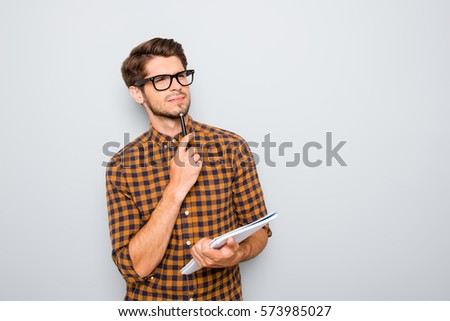 Young thoughtful nerd in glasses thinking about test.