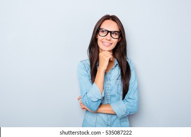 Young thoughtful secretary in glasses dreaming on gray background - Powered by Shutterstock