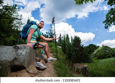 Young thoughtful tired man sitting on the stone while having a rest after hiking - Powered by Shutterstock