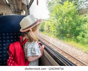 Young three year old girl looking out of a train window, London, UK