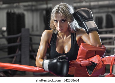 Young tired boxer woman standing on ring and resting. Sweat wet skin.  - Powered by Shutterstock