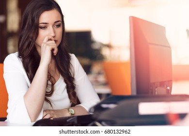 Young tired business woman with headache sitting in workplace