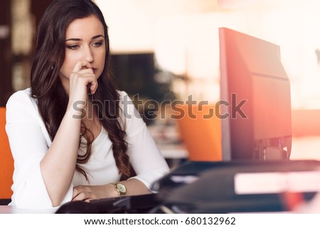 Young tired business woman with headache sitting in workplace