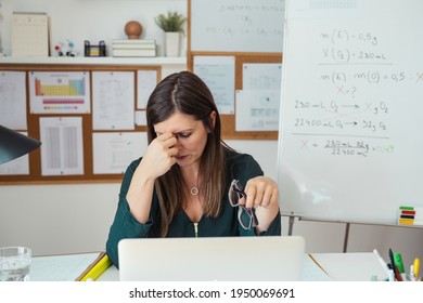 Young tired female professor having headache.
Teacher holding online class for e-learning students at home during COVID-19 pandemic period. Stressed woman take off glasses feel pain rub closed eyes - Powered by Shutterstock