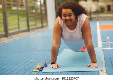 Young tired plus size woman. Girl training in a park.