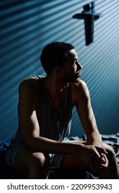 Young Tired And Unhappy Man Looking At Moonlight Coming Through Window Of His Bedroom While Sitting On Bed At Midnight