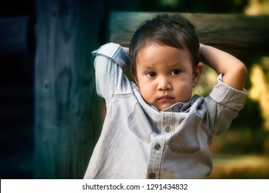 Young Toddler Boy That Looks Troubled, Worried, Or Expressing Anti Social Behavior While Holding His Head With His Arms.