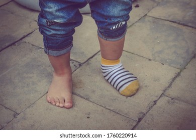 Young Toddler Feet With One Sock On, Funny Baby Feet One Sock. Cute Baby Feet.