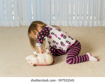 Young Toddler Getting Money From Pottery Piggy Bank