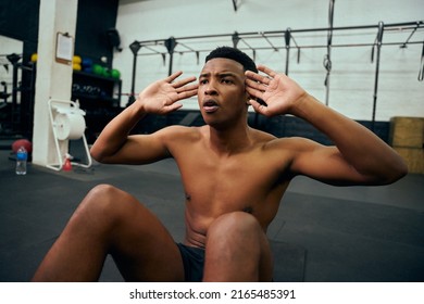 Young, Topless African American Male Doing Sit-ups On The Floor In The Gym. Mixed Race Male Personal Trainer Doing Cross Training Indoors. High Quality Photo