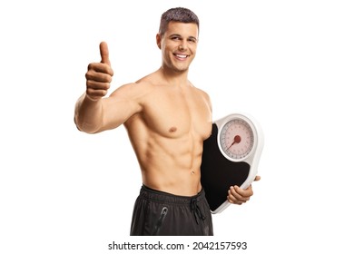 Young topless man holding a weight scale and gesturing thumbs up isolated on white background