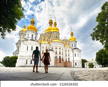 Young tourist couple in silhouette looking at Church with golden domes at Kiev Pechersk Lavra Christian complex. Old historical architecture in Kiev, Ukraine - Shutterstock ID 1126526102