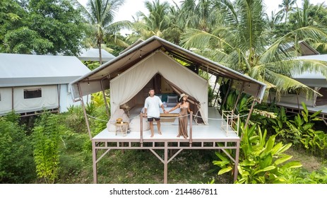 Young Tourist Couple Standing In Front Of A Luxury Camping Tent In A Tropical Jungle