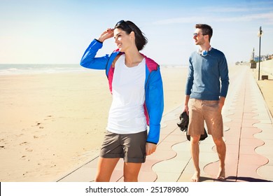 Young tourist couple standing on a beach boardwalk - Powered by Shutterstock