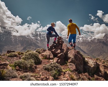 Young tourist couple watching spectacular mountain scenery of Jebel Toubkal range in High Atlas mountains Morocco, Africa