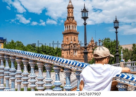 young tourist eaning on the railing, admiring the Spanish Square in Seville

