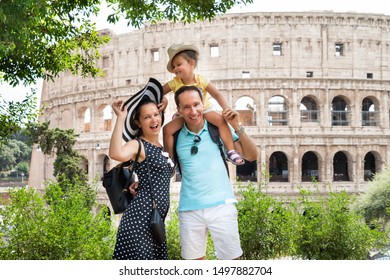 Young Tourist Family Standing In Front Of Colosseum In Rome, Italy