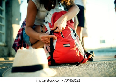 Young Tourist Girl Is Packing Her Backpack And Hat.