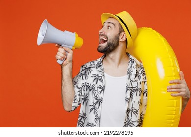 Young Tourist Man Wear Beach Shirt Hat Hold Inflatable Ring Scream Aside In Megaphone Announces Discounts Isolated On Plain Orange Background Studio Portrait. Summer Vacation Sea Rest Sun Tan Concept