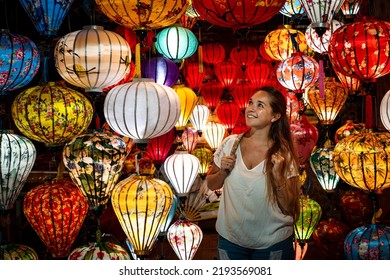 Young tourist surrounded by beautiful paper lanterns in Hoi An, Vietnam. Tourist dazzled by beautiful paper lanterns in Hoi An.