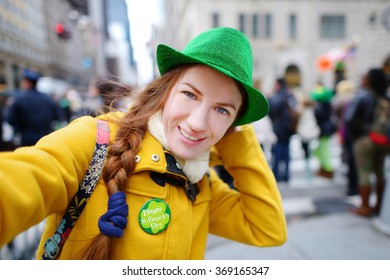 Young tourist taking a selfie with her smartphone during the annual St. Patrick's Day Parade on 5th Avenue in New York City