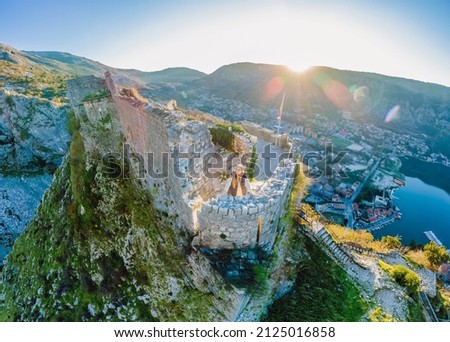 Young tourist woman enjoying a view of Kotor Bay, Montenegro. Kotor Old Town Ladder of Kotor Fortress Hiking Trail. Aerial drone view