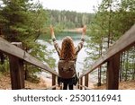 Young tourist woman enjoys the view of the mountain lake. Solitude with nature. Active lifestyle.