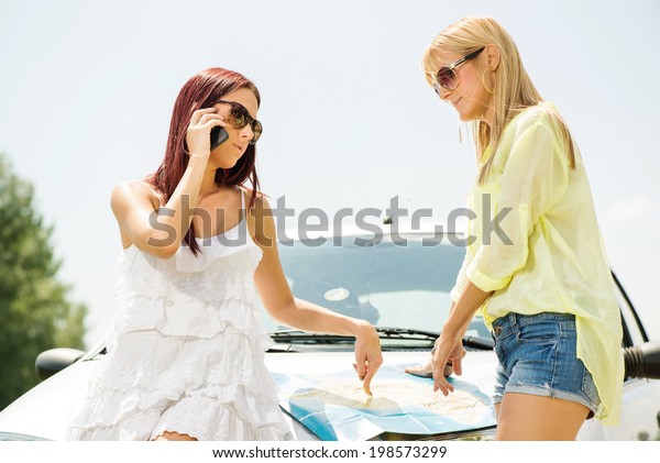 Young Tourist Woman Making Phone\
Call and asking for direction, because she is lost on the\
road.